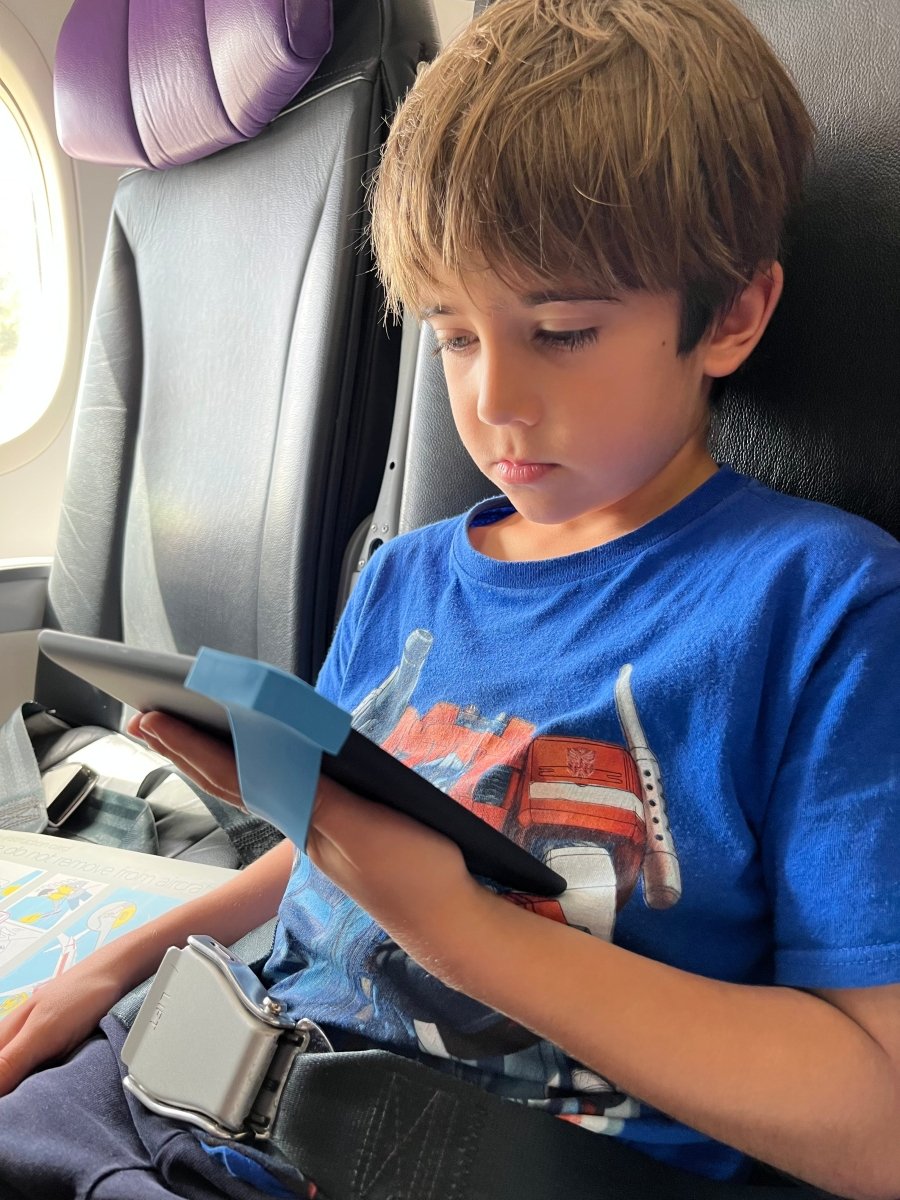 Copy_of_Leo_on_the_plane_holding_a_kindle_with_blue_strapsicle.JPG